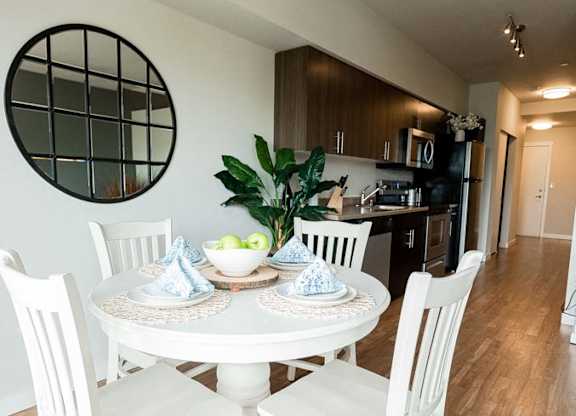 A white dining table with four chairs and a bowl of fruit on it. at The Platform, Washington, 98032