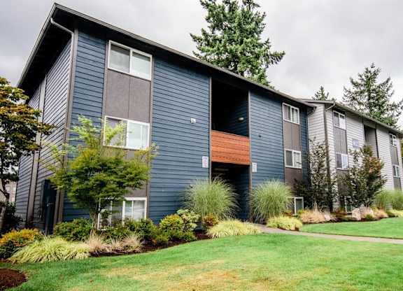 A row of modern townhouses with a green lawn in front. at Vibe, Kent, WA