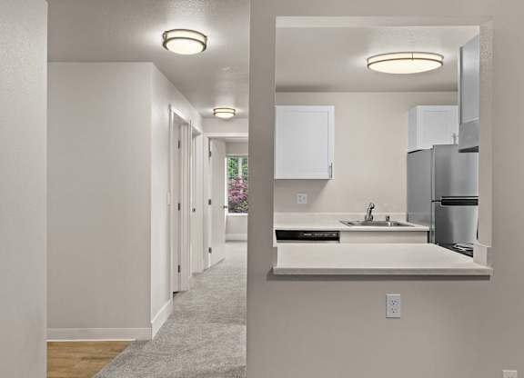 a kitchen with a sink and a refrigerator in a house at Bellamy Park Apartments , Lakewood, 98498