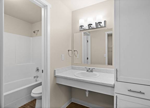 a bathroom with a sink and a mirror and a shower at Bellamy Park Apartments , Lakewood, CA
