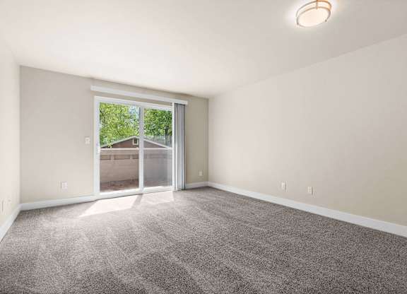an empty living room with a large window and carpet at Bellamy Park Apartments , Lakewood, CA, 98498
