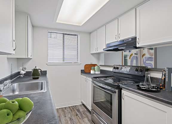a kitchen with stainless steel appliances and white cabinets at The Verandas, Washington, 98466