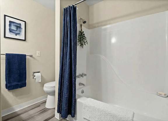 A blue towel hangs on a towel rack in a bathroom.