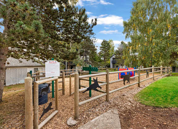 A sign is posted on a fence in a park.