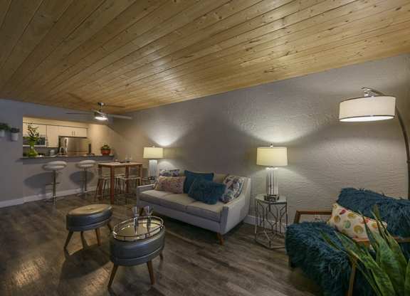 A living room with a white couch and a wooden ceiling.