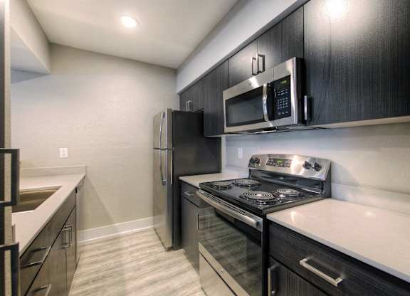 A modern kitchen with a black fridge and stove.