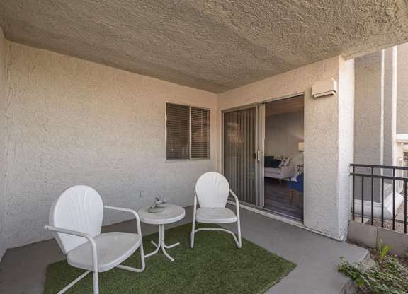 A patio with two chairs and a table.