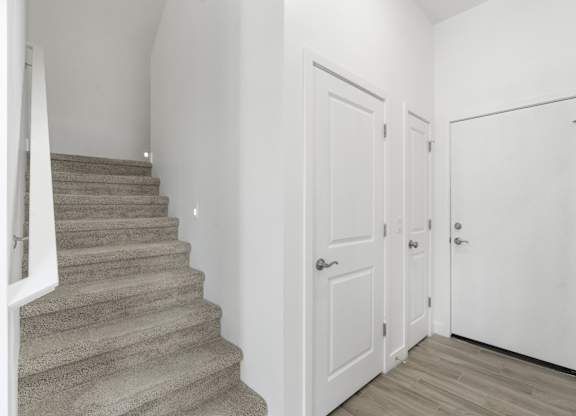 A staircase with a carpeted runner and a white railing.