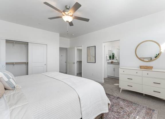 A bedroom with a large bed, a dresser, and a mirror.