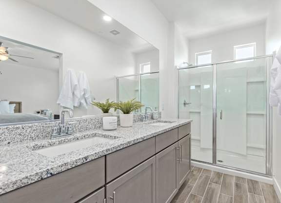 A bathroom with a marble countertop and a large mirror.