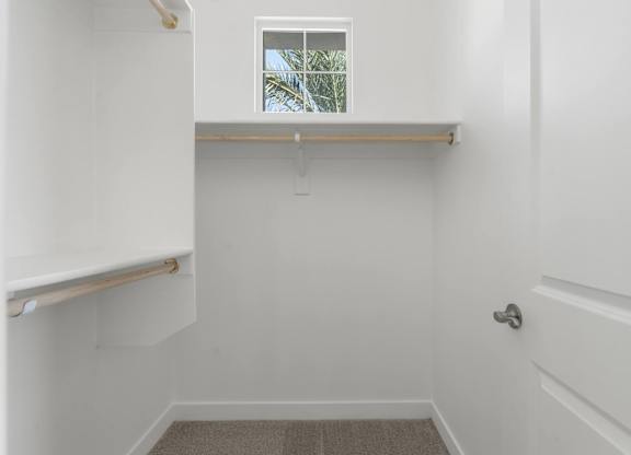 A white bathroom with a window and a door.