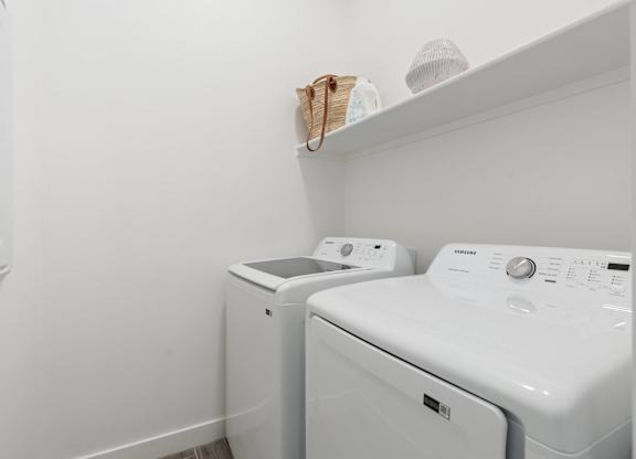 A white washing machine and dryer in a small laundry room.