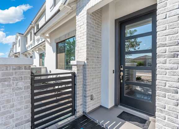 A modern house with a black gate and a glass door.