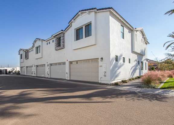 A large white house with a garage door and a driveway.