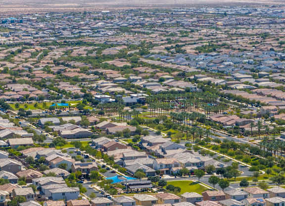 A bird's eye view of a residential neighborhood with houses and swimming pools.
