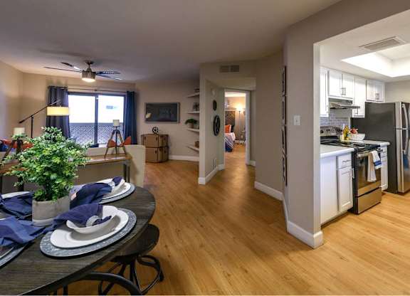 A kitchen with a table and chairs in front of it.