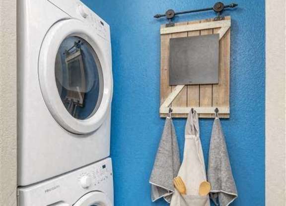 A washing machine is placed next to a dryer in a laundry room.