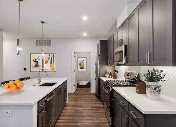 A modern kitchen with dark wood cabinets and white countertops.