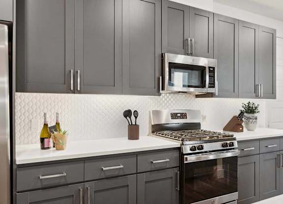 A modern kitchen with a stove, microwave, and oven.