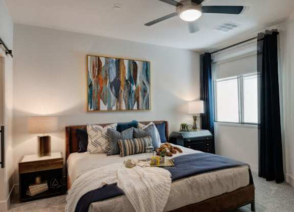 A bedroom with a large bed and a painting on the wall.
