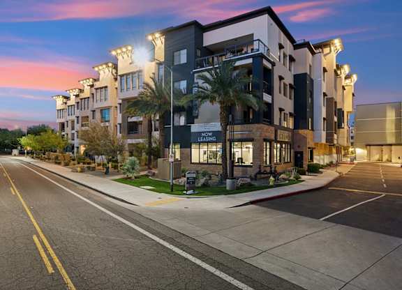 A street view of a newly leased apartment building at dusk.