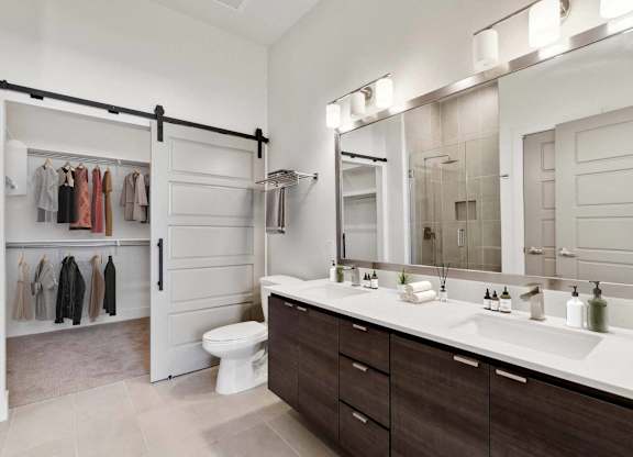A bathroom with a white counter top and a white toilet.