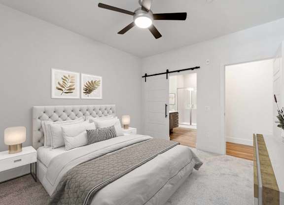 A bedroom with a large bed and a ceiling fan.