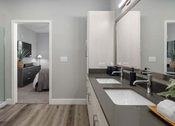 A modern bathroom with a walk-in shower and double sink vanity.