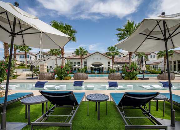 A poolside area with lounge chairs and umbrellas.