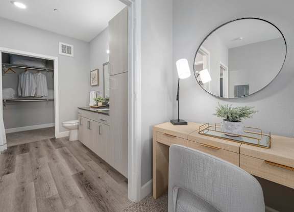 A room with a desk, chair, and a mirror.