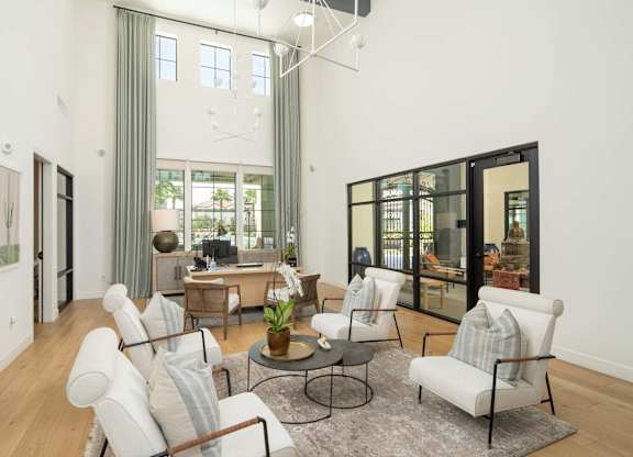 A living room with a white couch and a glass table.