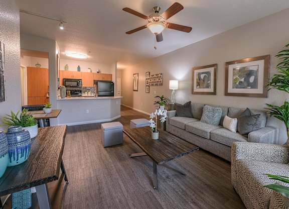 A living room with a couch, coffee table, and a ceiling fan.