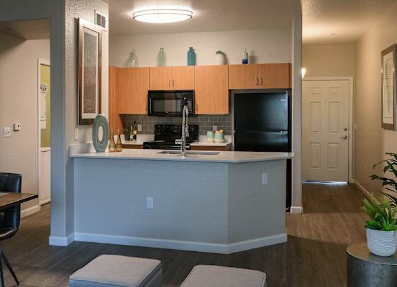 A kitchen with a black counter top and a white island.