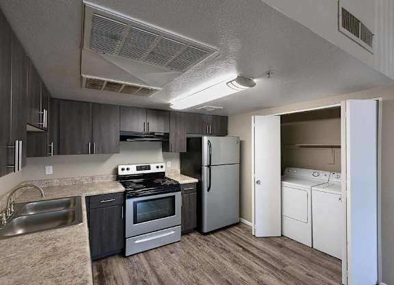 A kitchen with a stove, oven, refrigerator, and dishwasher.
