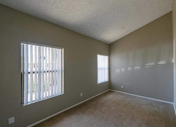 A room with a window and a wall-mounted shelf.