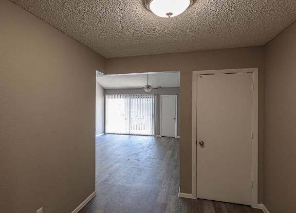 A room with a door and a window with blinds.