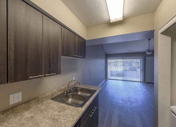 A kitchen with brown cabinets and a sink.