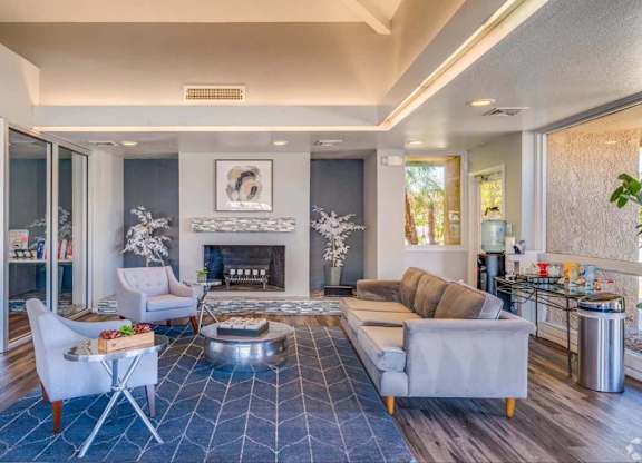 A modern living room with a fireplace and a blue rug.