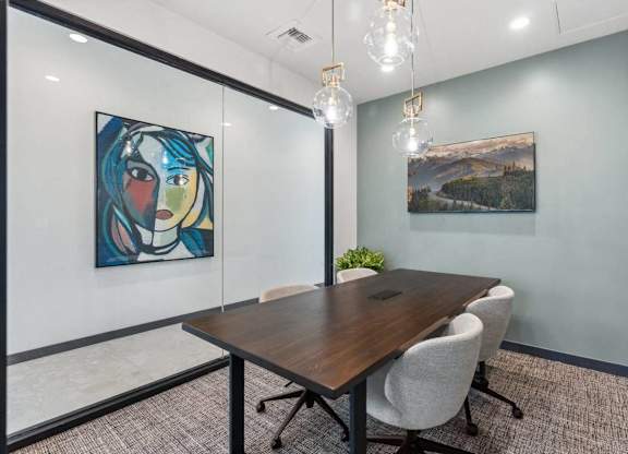 A conference room with a wooden table and chairs.