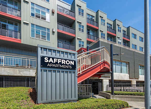 A multi-story building with a sign that says Saffron Apartments.