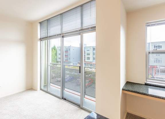 A room with a large window overlooking a parking lot.