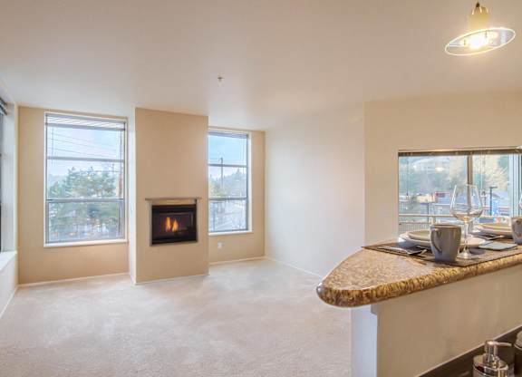 A living room with a fireplace and a dining table.