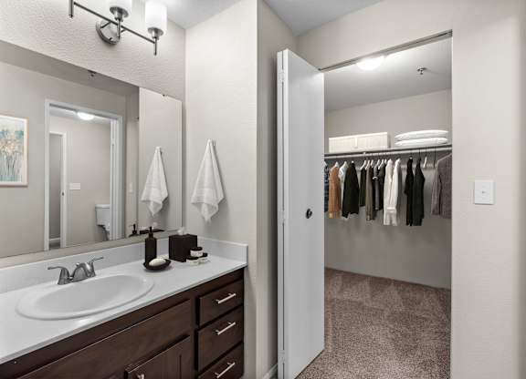 A bathroom with a white sink and a mirror.
