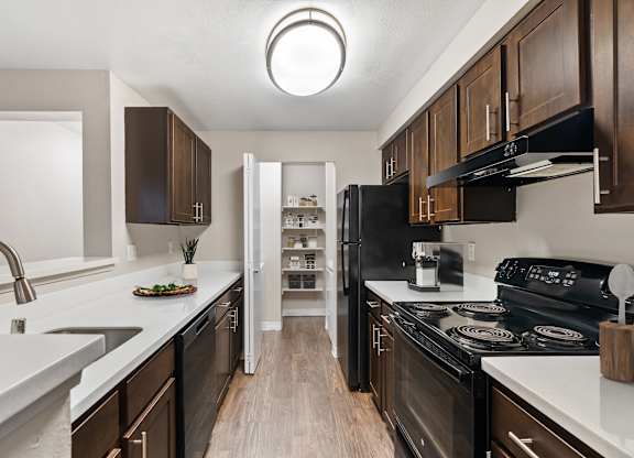 A modern kitchen with dark wood cabinets and white countertops.