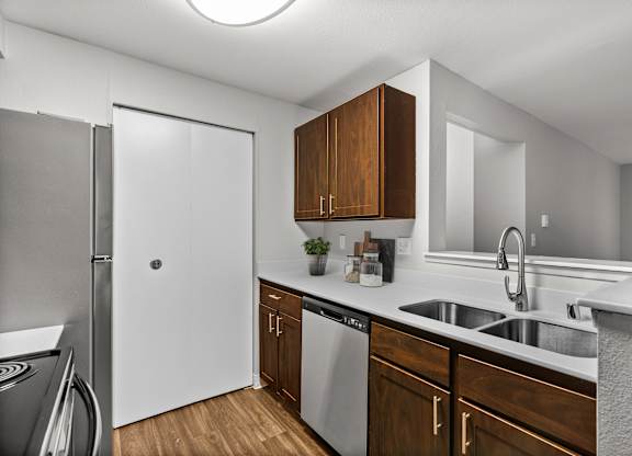 A kitchen with a white fridge and a white sink.