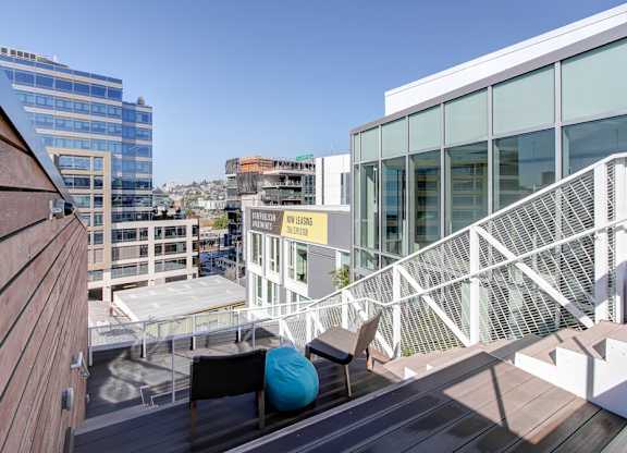 A balcony with a white railing and a blue bean bag chair.