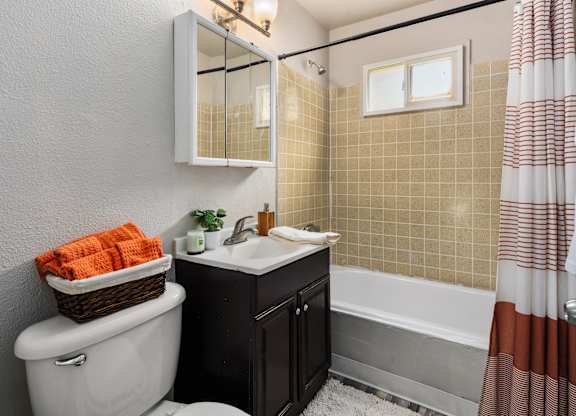 A bathroom with a white toilet, a sink, and a bathtub.