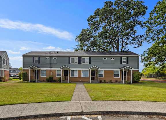 A row of houses with a tree in the back.