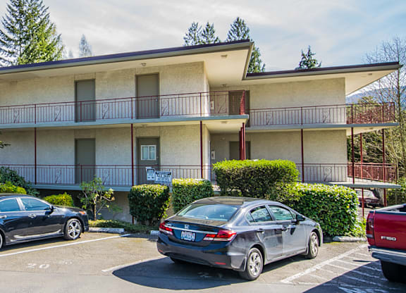 an apartment building with cars parked in front of it