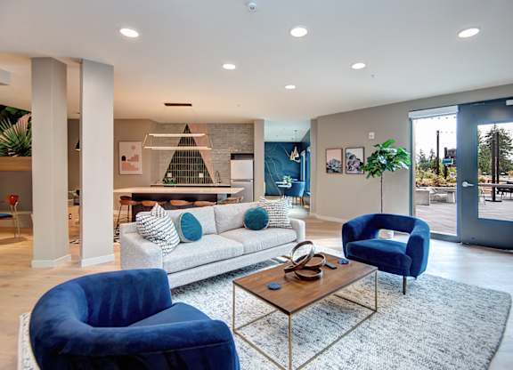 a living room with blue chairs and a couch at Hazel Apartments, Washington, 98026